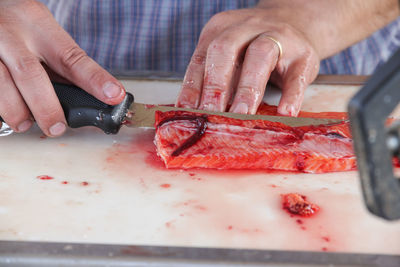 Close-up of man cutting fish