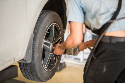 Midsection of man holding camera in car