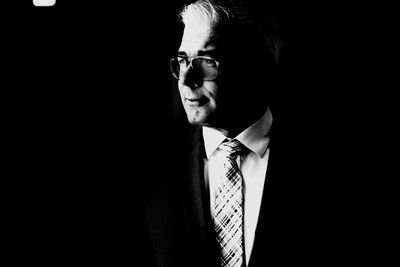 Portrait of young man against black background