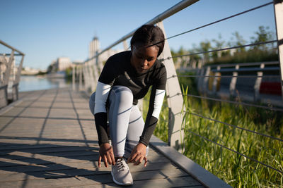 Black runner tying shoelaces during training