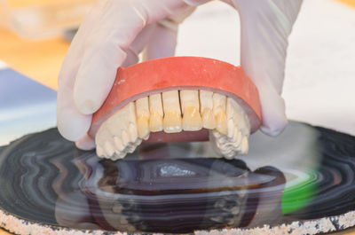 Cropped image of hand holding dentures