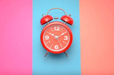 Close-up of clock against red background