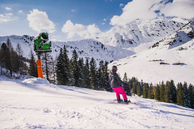 Rear view of person skiing on field against mountain