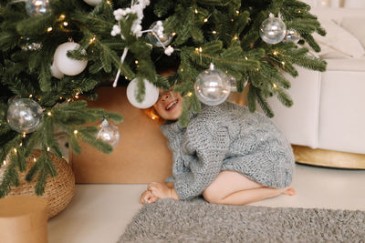 Little girl child in knitted sweater having fun playing christmas holiday in decorated house