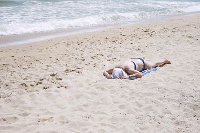 Woman relaxing at beach on sunny day