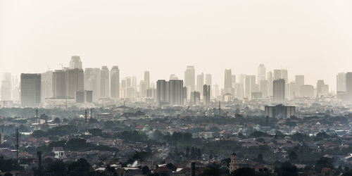 Aerial view of buildings in city against clear sky