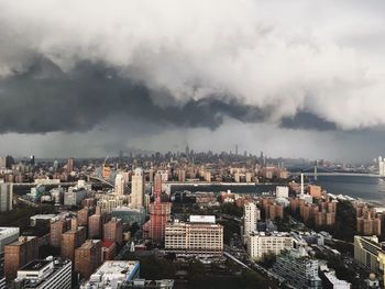 Aerial view of city against cloudy sky