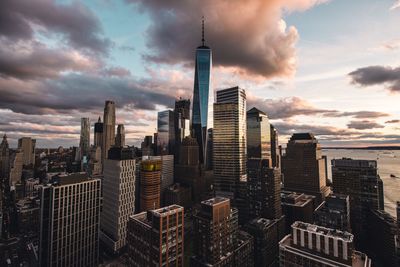 Skyscrapers in city against cloudy sky