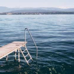 Ladder on lake against sky