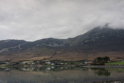 Scenic view of lake by mountains against sky