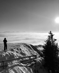 Man standing on snow covered mountain against sky