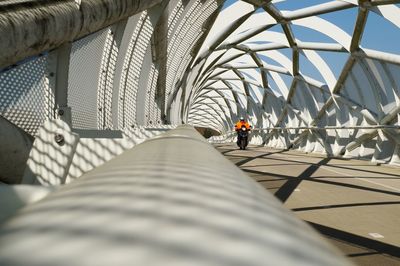 Rear view of person walking on footbridge