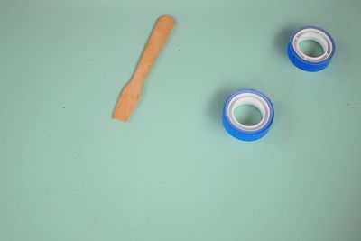 High angle view of adhesive tapes and wooden spoon on table
