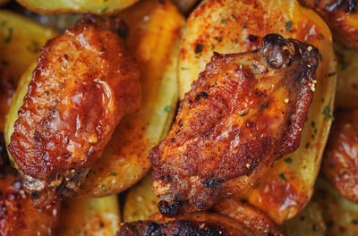 High angle view of baked potato with barbecue chicken wings 