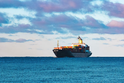 Ship sailing on sea against sky