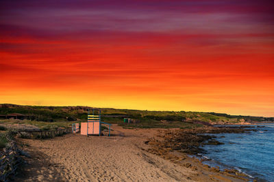 Scenic view of beach against orange sky