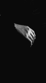 Close-up of hand over black background