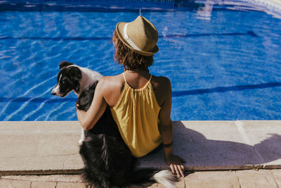 Rear view of woman sitting in swimming pool