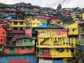 Residential buildings by river against sky in city