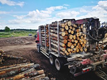 Stack of logs against sky