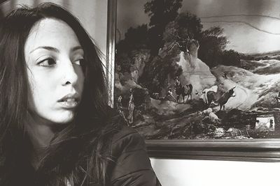 Close-up portrait of young woman with cat on window