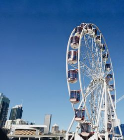 Low angle view of ferris wheel against blue sky