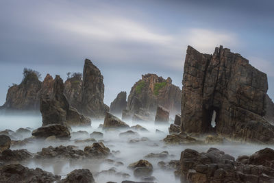 View of rocks in sea against sky