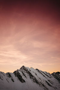 Scenic view of snowcapped mountains against sky during sunset