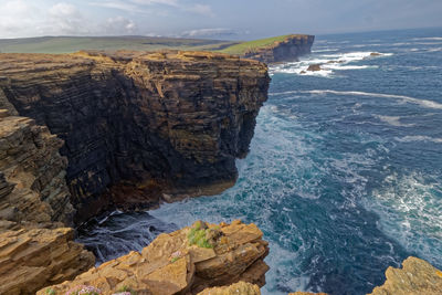 Rock formations by sea against sky