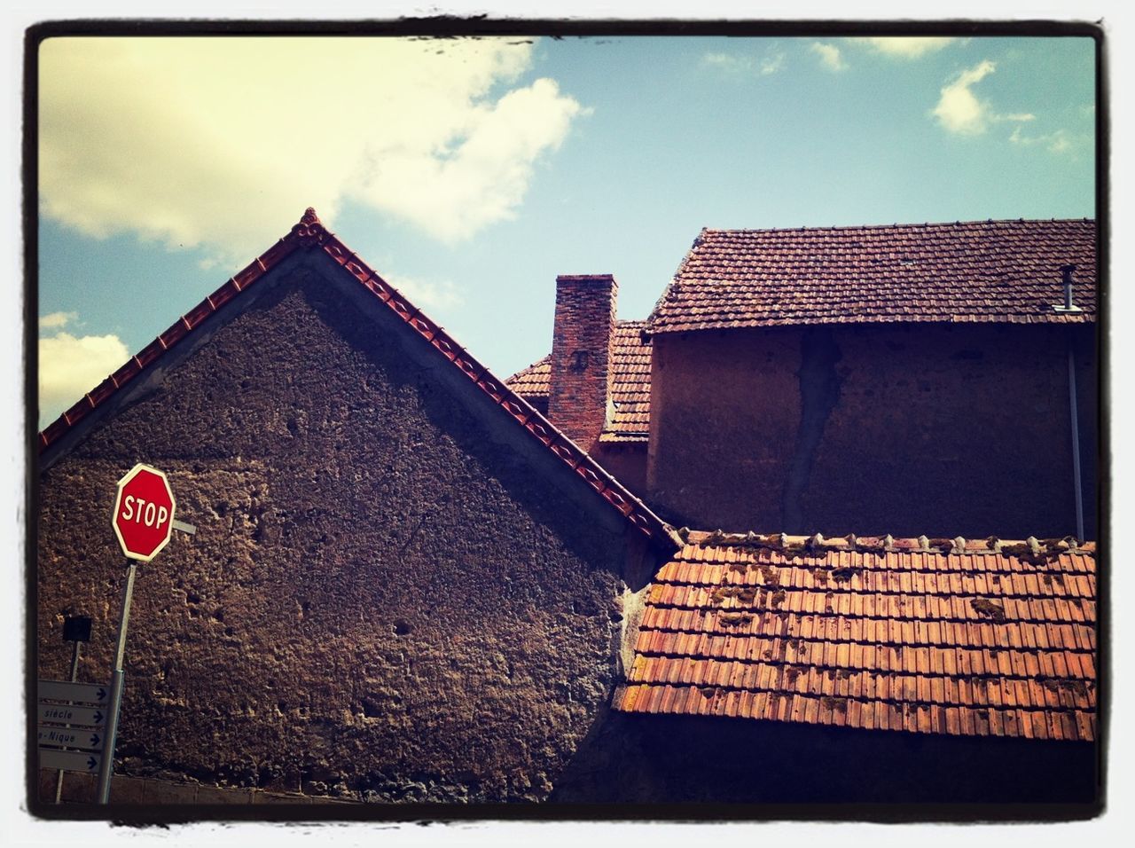 transfer print, sky, auto post production filter, cloud - sky, building exterior, architecture, built structure, low angle view, cloud, cloudy, red, day, outdoors, no people, blue, sunlight, wall - building feature, flag, roof, brick wall