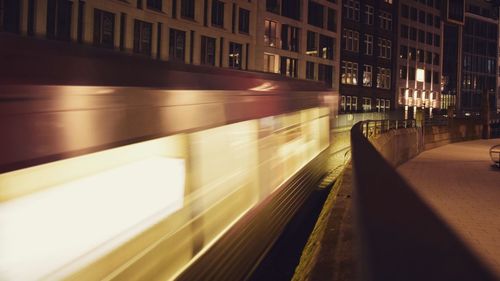 Illuminated railroad tracks in city at night