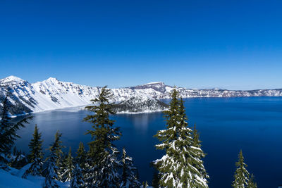 Scenic view of snowcapped mountains against clear blue sky