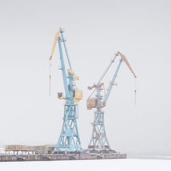 Cranes against clear sky