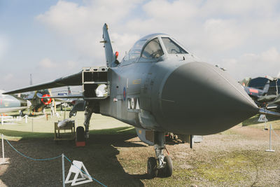 Fighter plane on field against sky