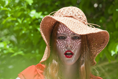 Close-up portrait of young woman with shadow on face