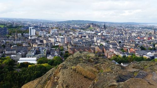 Aerial view of cityscape against cloudy sky