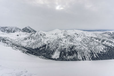 Scenic view of snow covered mountains against sky