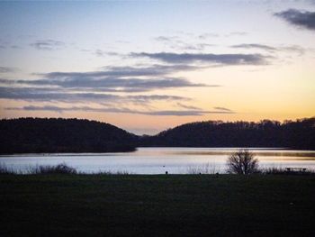 Scenic view of lake against sky at sunset