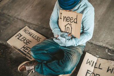 High angle view of man sitting on street