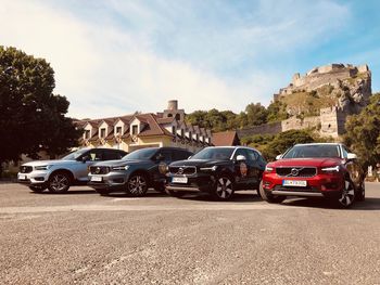 Cars on road in city against sky