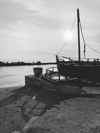Sailboats moored on beach against sky