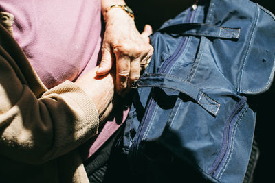 Midsection of woman sitting with luggage