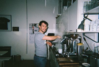Portrait of young man standing at home