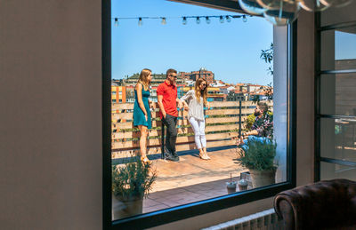 Rear view of woman looking through window