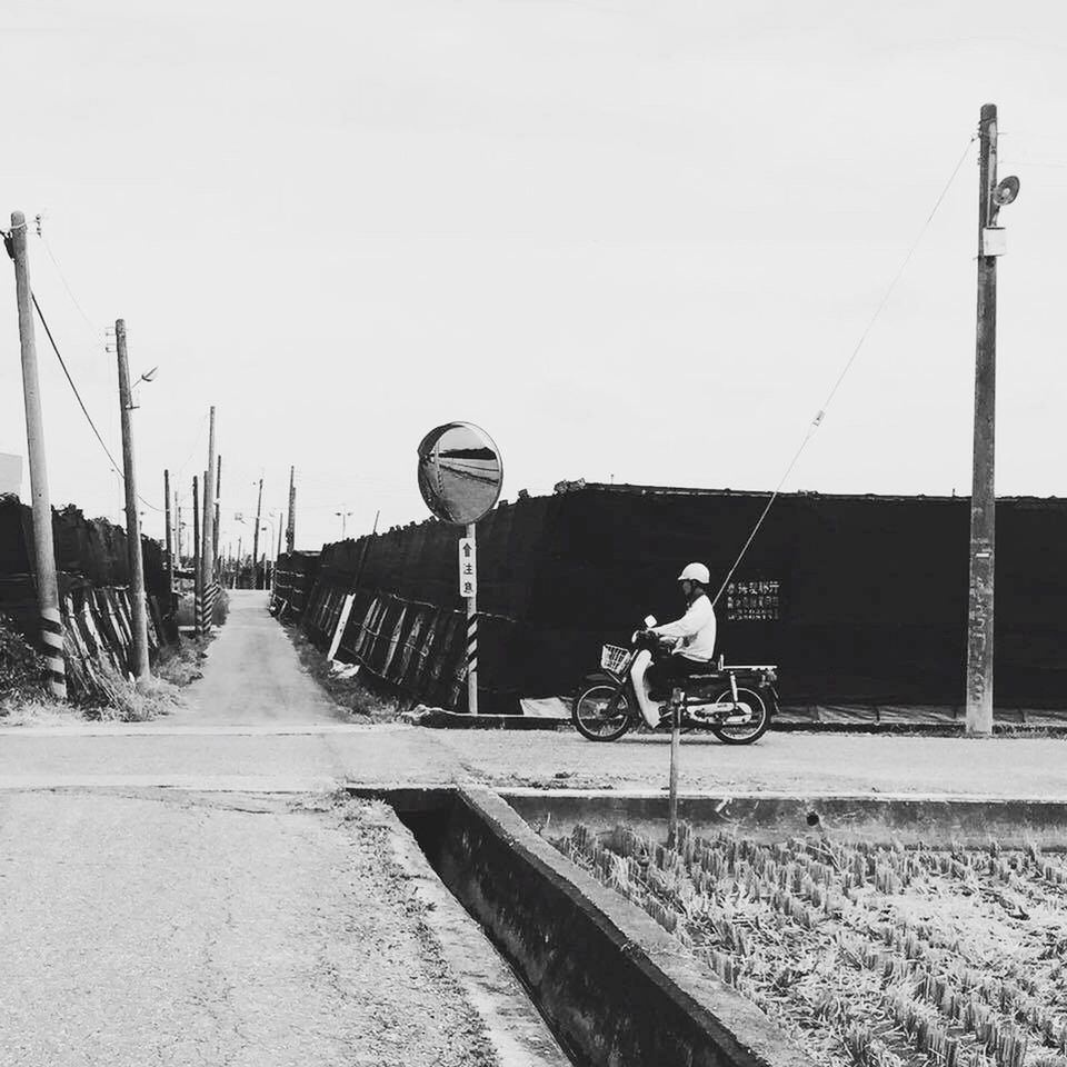 MAN ON MOTORCYCLE AGAINST SKY