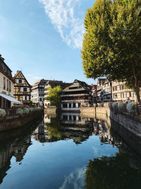 Buildings by river against sky in city in strasbourg, france