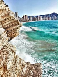 Scenic view of sea and cityscape against sky