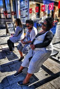 People sitting on street in city