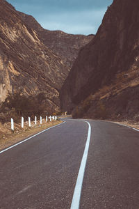 Road by mountain against sky