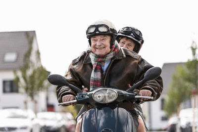 Happy senior couple riding motor scooter